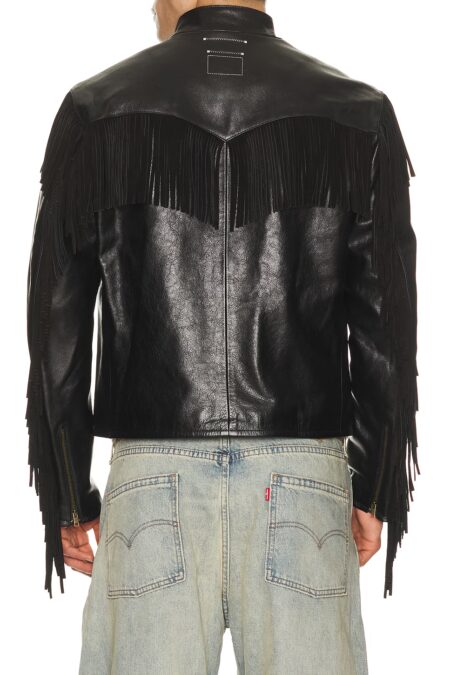 Back view of a model wearing a black leather western cafe racer jacket, highlighting the V-shaped yoke and long fringe accents flowing along the shoulders and down the sleeves.