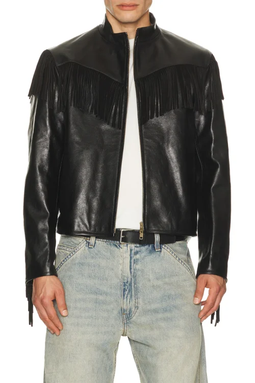 A close-up crop of a model wearing a black heavyweight cowhide leather jacket with a stand-up collar, front metal zipper, and distinct fringe paneling draping across the chest.