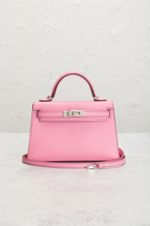 Luxury pink calfskin leather handbag photographed from the front with a detachable shoulder strap, structured top handle, and silver hardware against a neutral studio backdrop.