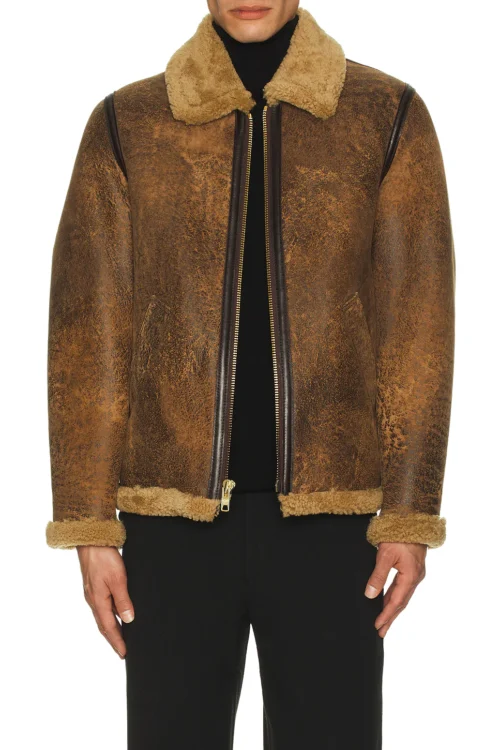 Model wearing a partially unzipped brown cowhide shearling jacket over a black turtleneck top, showcasing open shearling lapels and brass zipper detail.