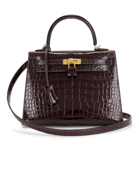 Front view of a structured dark brown shiny alligator leather handbag with polished gold-tone hardware, top handle, leather clochette, detachable shoulder strap, and elegant craftsmanship displayed on a white background.