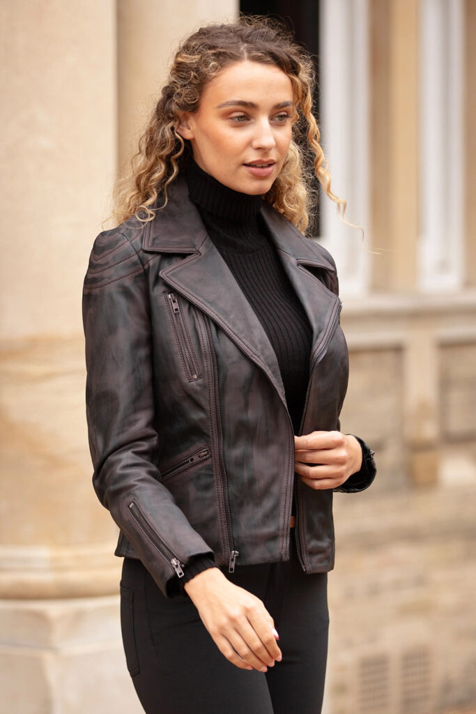 Women's Premium Black Leather Jacket | Luxury Outerwear | REVOLVE COLLECTION Woman wearing a premium black leather biker jacket over a black turtleneck sweater, showcasing a modern luxury outerwear style.