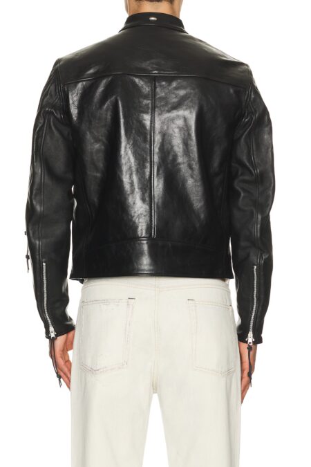 The back view of a person wearing a black leather jacket, highlighting the clean horizontal shoulder yoke panel, center back seam, and distinctive zipper details with pulls on the sleeves.