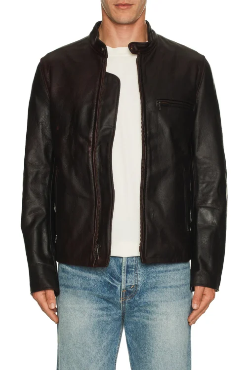 Cropped front view of a model wearing an open dark brown leather cafe racer jacket over a plain white crewneck t-shirt and light blue jeans.