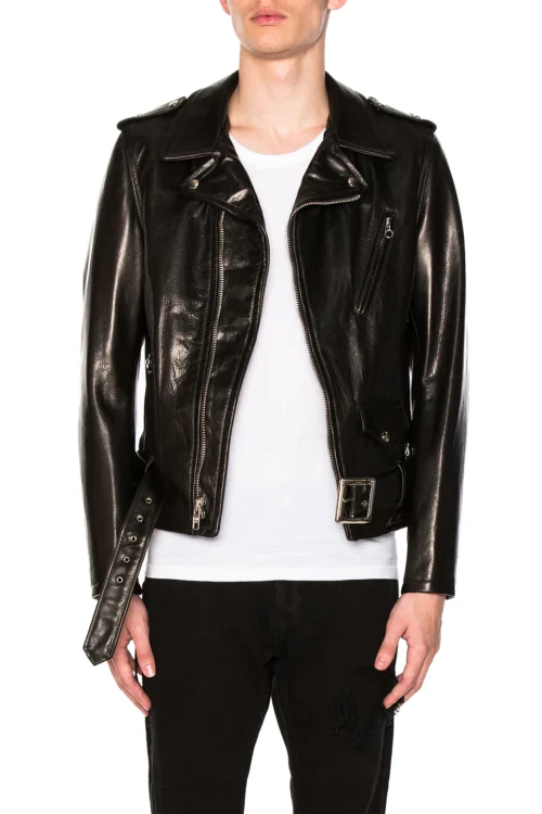 Cropped waist-up front view of a model wearing an open black pebbled leather moto jacket styled over a plain white t-shirt, showing wide lapel collars, asymmetrical zip closure, snap flap coin pocket, and hanging waist belt.